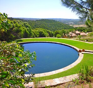 Naturteich als Pool umgeben von Rasen mit wunderschönem Ausblick