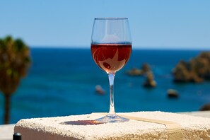 Glas Rosé In Casa Oystra mit Blick auf die Bucht von Praia Dona Ana