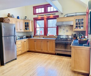 Kitchen with double oven gas stove, fridge, waffle maker, Kitchen Aid, blender