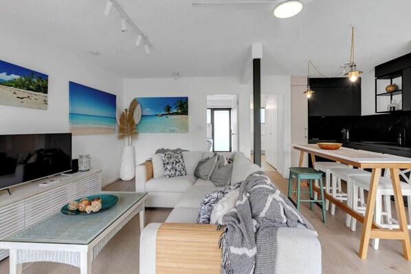 The living area offers an oversized L-shaped lounge to relax on in front of the TV.