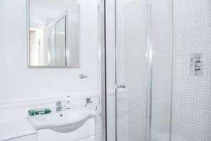 The large bathroom boasts a generous shower area that affords plenty of space for comfortable use. Additionally, the bathroom is fully equipped with complimentary shampoo and shower gel, ensuring the convenience of guests.