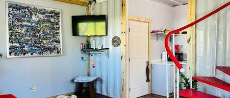 View of the living room area, full bathroom & kitchen.