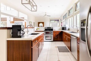 Large modern kitchen with propane stove, two sinks, dishwasher and ice maker.
