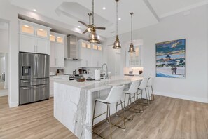 A quartz island separates the kitchen from the main living area and provides an eating bar with bar stool seating.