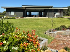 The back yard and street view of the property on arrival. With gorgeous inlet views straight through the house.