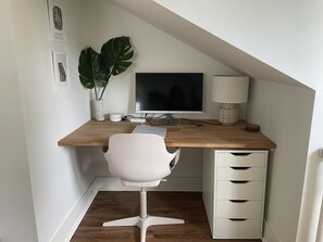 A dedicated workspace with warm lighting and cables for the monitor
