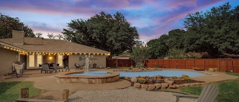 Check out this beautiful backyard oasis! Equipped with a pool, patio, fire pit, loungers, and a hammock, what more could one ask for?!