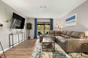 Open concept living/dining with dining seating for 6. Sliding doors access to private patio. 70” Smart TV