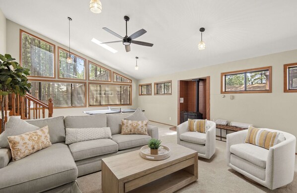 Sunken living room lounge area. Electric woodstove between the lounge and table.