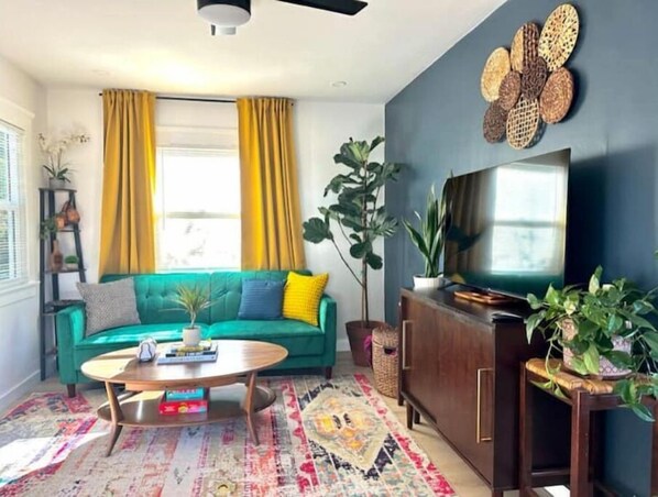 Bright and colorful living room with 50" smart tv and 2 sleeper couches.