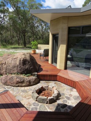 Iron bark deck featuring natural granite boulder setting with personal firepit 