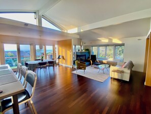 View of main living, dining area, kitchen with vaulted ceilings, sea views 