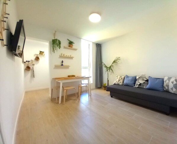 Living room with dining table, flat TV. 