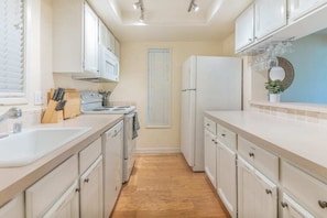 The fully equipped kitchen boasts modern appliances including a stove, oven, refrigerator, dishwasher, and microwave, along with cookware and utensils for your culinary adventures.