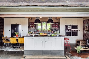 Luxury huge open plan kitchen extendable chef table full width bifold doors 