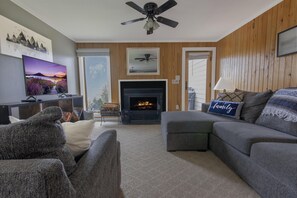 The living area, perfect for lounging, has plenty of seating, a Smart TV, and a wood burning fireplace.