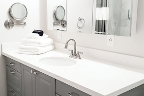 Bathroom vanity with fluffy towels laid out for guests.