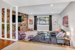 Spacious family room with wood burning fireplace and 65" 4h TV