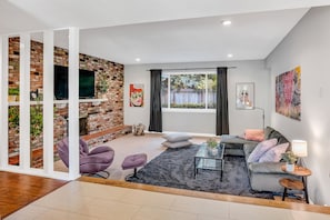 Spacious family room with wood burning fireplace and 65" 4h TV