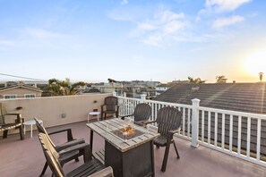 Rooftop Deck/Terrace with ample seating, a fire pit, BBQ, & counter area.