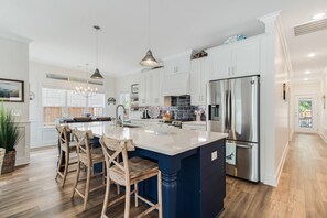 The Nautical Navy of the Large Island & the Backspace is offset by the bright white of the Cabinetry. 3 Seats at the Bar.