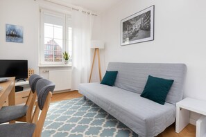 Comfortable living room featuring a modern sofa, coffee table, and a patterned rug, creating a relaxing atmosphere.
