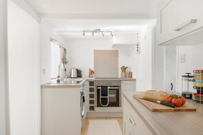 Copper Bal Cottage, Marazion. Ground floor: A well-equipped kitchen area with breakfast bar, electric oven, induction hob, fridge/freezer, microwave and washing machine