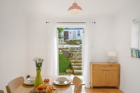 Copper Bal Cottage, Marazion. Ground floor: Dining area with dining table for four guests with patio doors leading out to the garden