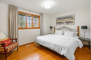 Bedroom 1 - King bed with clean linens, bedside lighting, closet, curtains. 