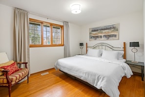 Bedroom 1 - King bed with clean linens, bedside lighting, closet, curtains.