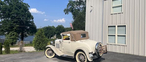 Model A sitting in front of Antique Hideaway overlooking lake