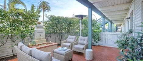 Spacious patio off of the kitchen with seating for 5 and relaxing fountain. Heat lamp in picture not included in rental.