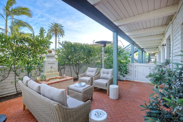 Spacious patio off of the kitchen with seating for 5 and relaxing fountain. Heat lamp in picture not included in rental.