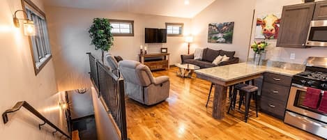 Open concept living space with vaulted ceilings and stools for 4