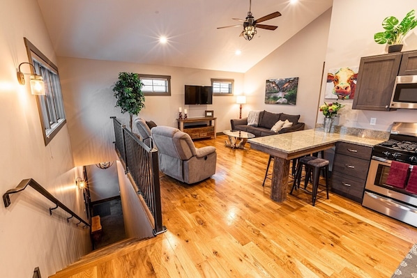 Open concept living space with vaulted ceilings and stools for 4