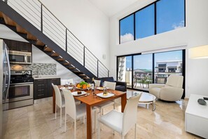 An open space concept living room and dining room with high ceilings. 