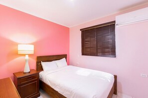 An air-conditioned bedroom with comfortable bed.