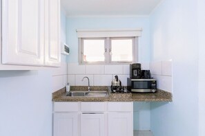 Equipped kitchen with fridge, microwave and coffee maker.
