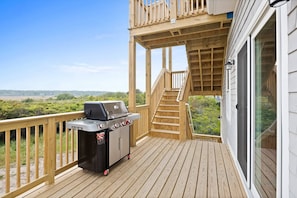 Deck area overlooking the marsh with propane grill.  Stairs ready up to roof deck