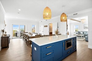 Another kitchen and dining area view with sliders out to deck with grill and roof deck access