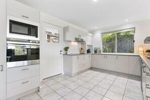 Large and functional kitchen with dishwasher, microwave, oven, stove and coffee.