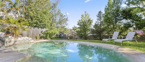 Large and private pool with a ramp to walk down and a seat to rest.