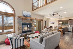 Living Room - The beautiful, open floor plan with a gas fireplace, a medium sized couch, two chairs, and tow beanbags keeps friends and family together while eating and relaxing!