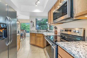 Fully equipped kitchen featuring brand new granite countertops, offering a stylish and functional space for all your cooking needs. Enjoy a delightful culinary experience!