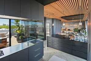 Chefs kitchen provides connection with pool deck and dining. It offers two preparation benches and sinks, Gaggenau appliances including induction hob and steam oven.