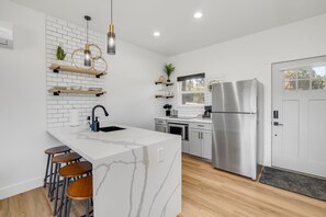 Full size kitchen with coffee machine, cooktop, refrigerator, dishwasher and microwave/convection oven