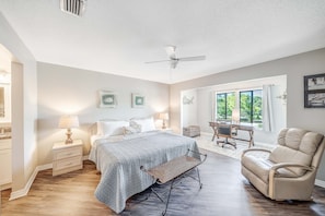 The master bedroom features a King size bed, dedicated workspace, flat screen television, ensuite bathroom, and views of Grand Lagoon.