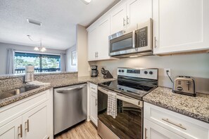 The fully equipped kitchen features granite countertops and stainless-steel appliances.