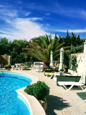 Community pool with sun loungers and outdoor shower