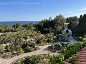 Jardín bien cuidado con zona de barbacoa y vistas al mar